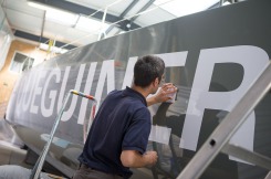 Pose de la decoration du monocoque Imoca Groupe Queguiner-Leucemie Espoir - Skipper : Yann Elies - Lorient le 11/05/2015